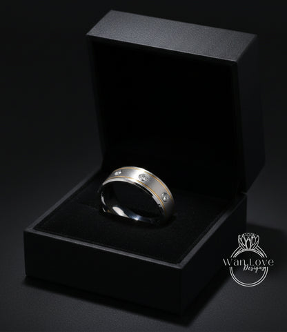 A silver ring with three diamonds is displayed in a black jewelry box against a dark background.