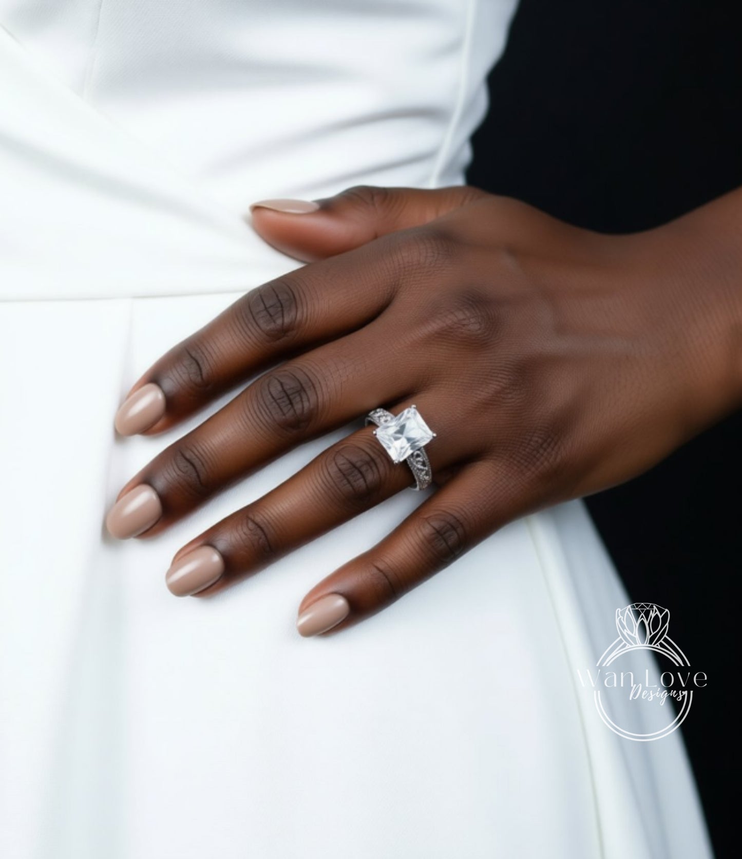 A close-up of a hand wearing a diamond engagement ring on the ring finger.