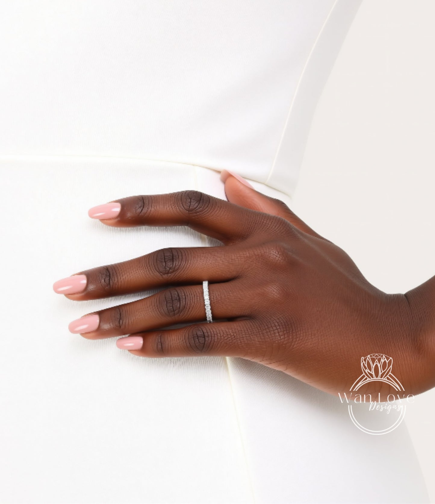 A close-up of a hand wearing a ring on the ring finger.