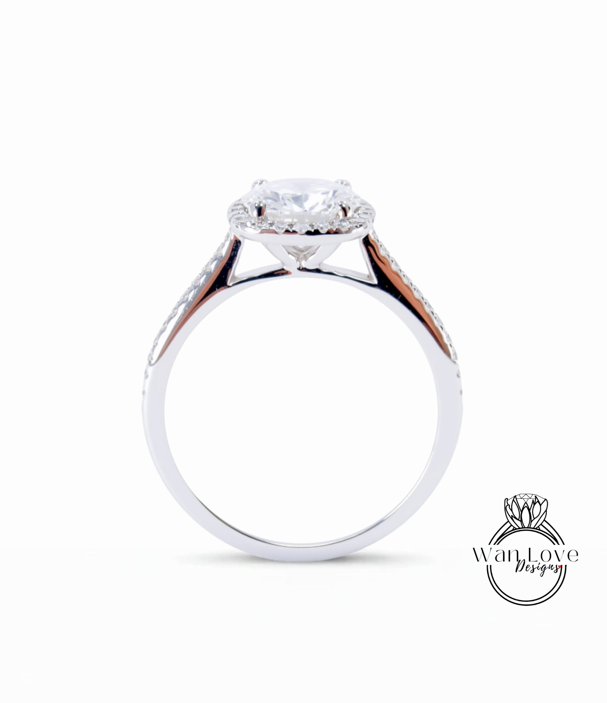 A silver engagement ring with a large central diamond and a halo of smaller diamonds around the center stone.