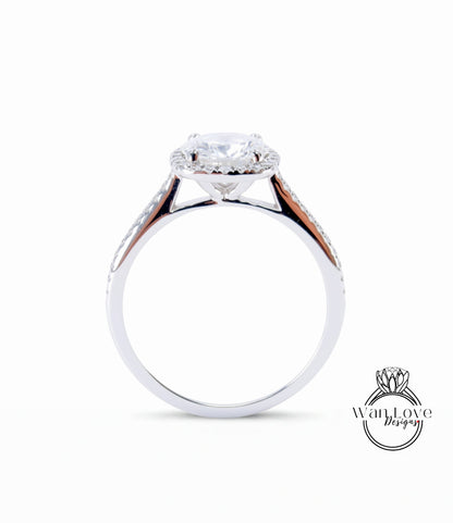 A silver engagement ring with a large central diamond and a halo of smaller diamonds around the center stone.