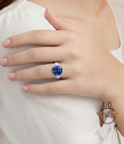 A close-up of a person's hand wearing a large, blue gemstone ring.
