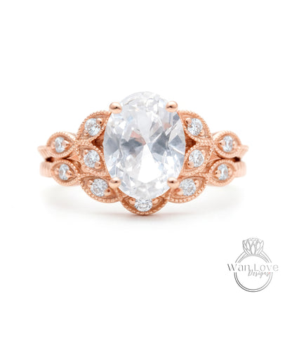 a beautiful engagement ring with a large oval-shaped gemstone surrounded by intricate floral designs and small diamonds.
