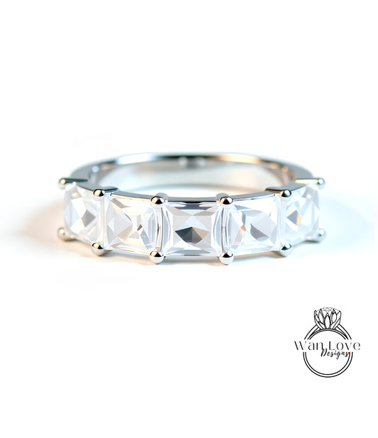 A close-up image of a silver ring with a row of clear gemstones, showcasing the intricate design and craftsmanship of the piece.