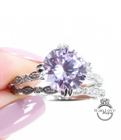 A close-up of a person's hand holding a ring with a large, round purple gemstone.