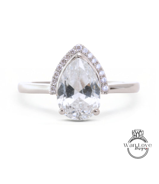 A close-up of a diamond engagement ring with a large, clear gemstone set in a silver band.