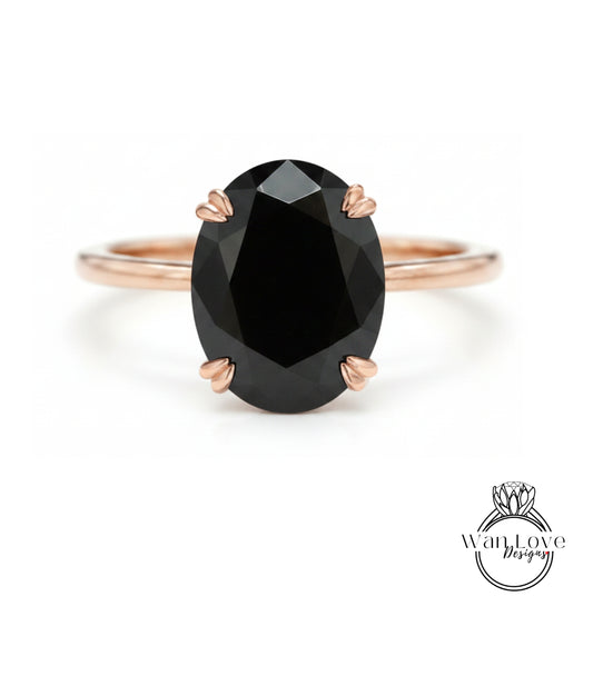 A rose gold ring with a large oval-shaped black gemstone set in the center.