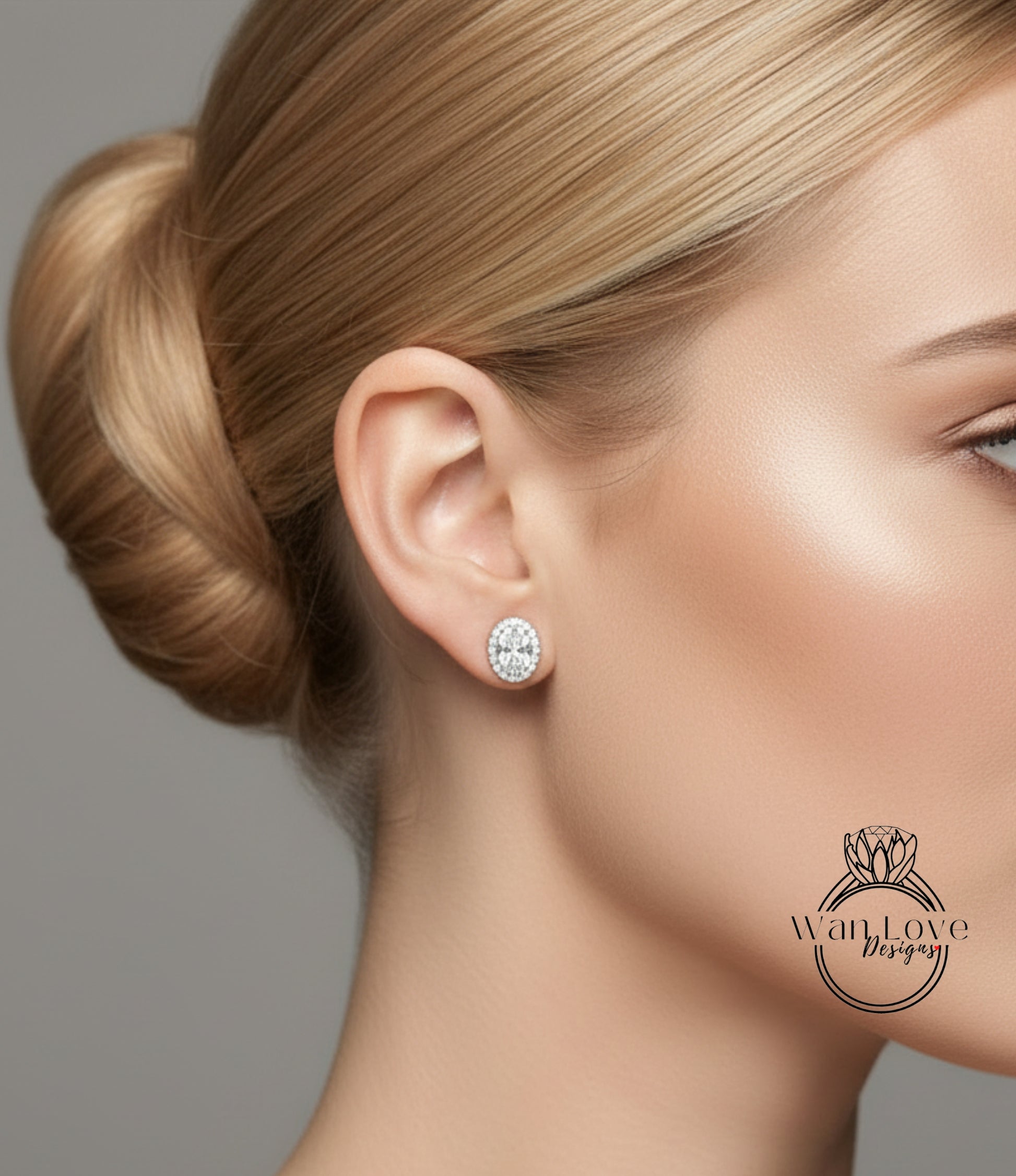 A close-up of a woman's face, focusing on her ear and cheek area. She has her hair in a bun and is wearing a diamond earring.