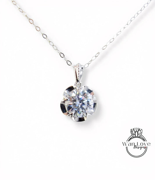 A close-up view of a delicate silver necklace with a large, brilliant-cut diamond pendant.