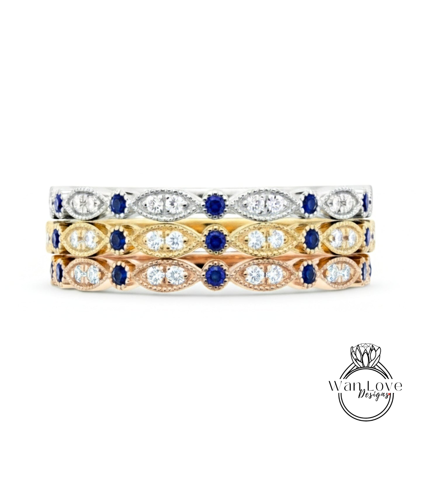 A three-tone ring with a gold band and a row of diamond-encrusted stones in various colors, including blue, yellow, and white.