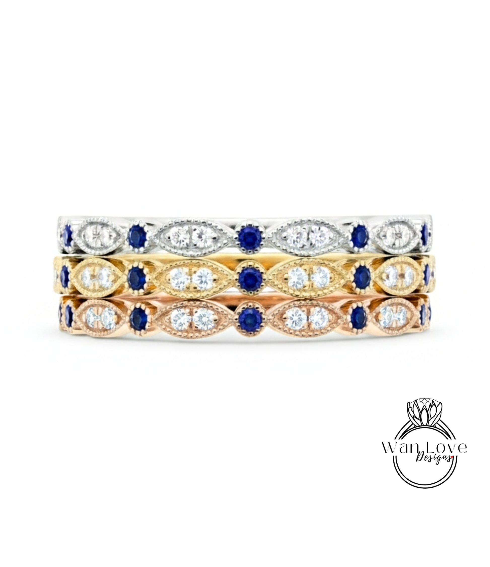 A three-tone ring with a gold band and a row of diamond-encrusted stones in various colors, including blue, yellow, and white.