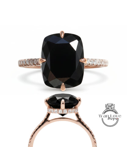 A large, black diamond ring with a rose gold band and a small diamond accent.
