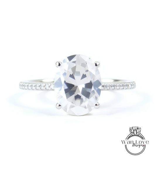 A close-up of a diamond engagement ring with a large oval-shaped diamond set in a silver band.