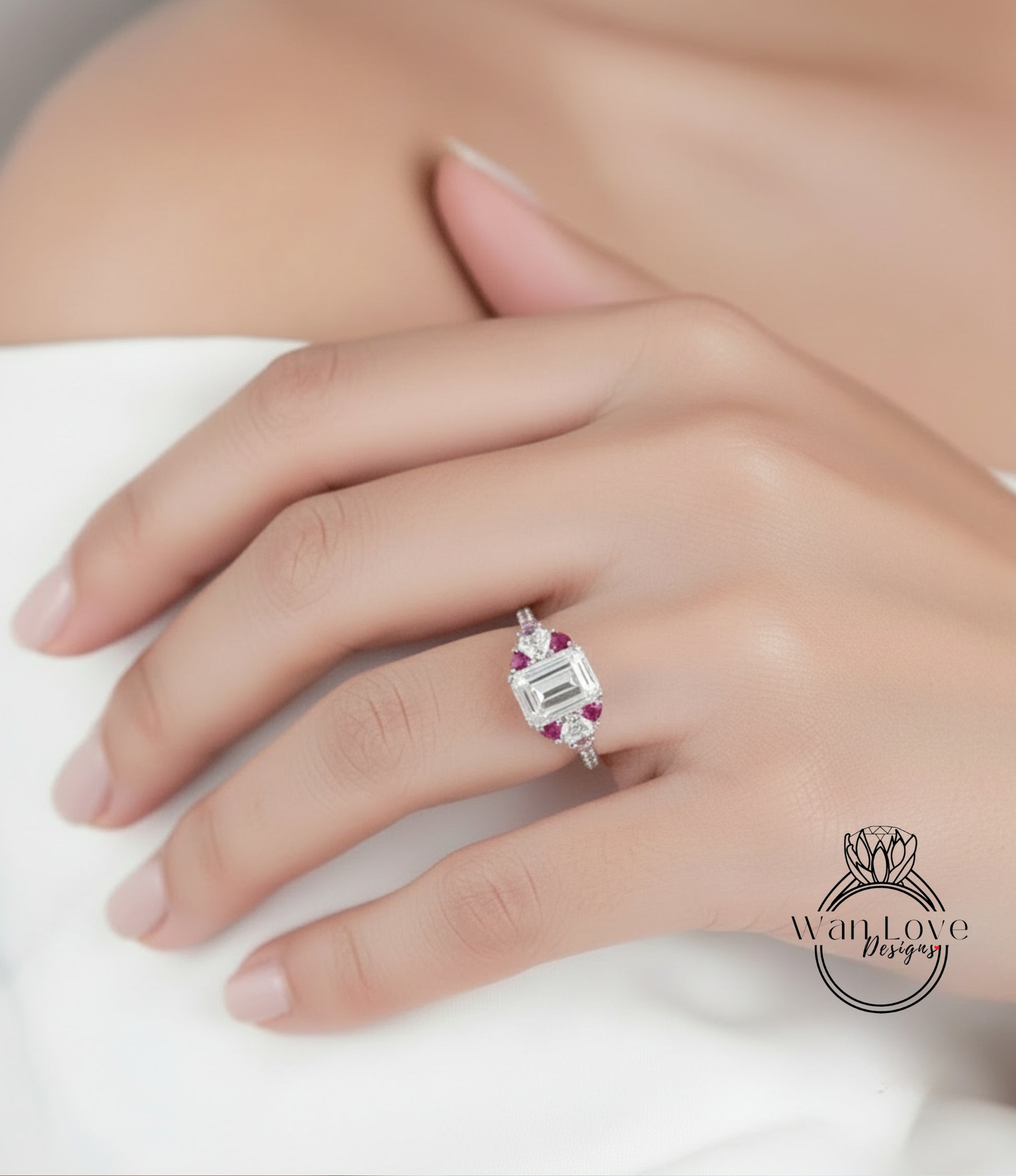 A close-up of a person's hand wearing a diamond engagement ring with a large central gemstone surrounded by smaller gemstones.
