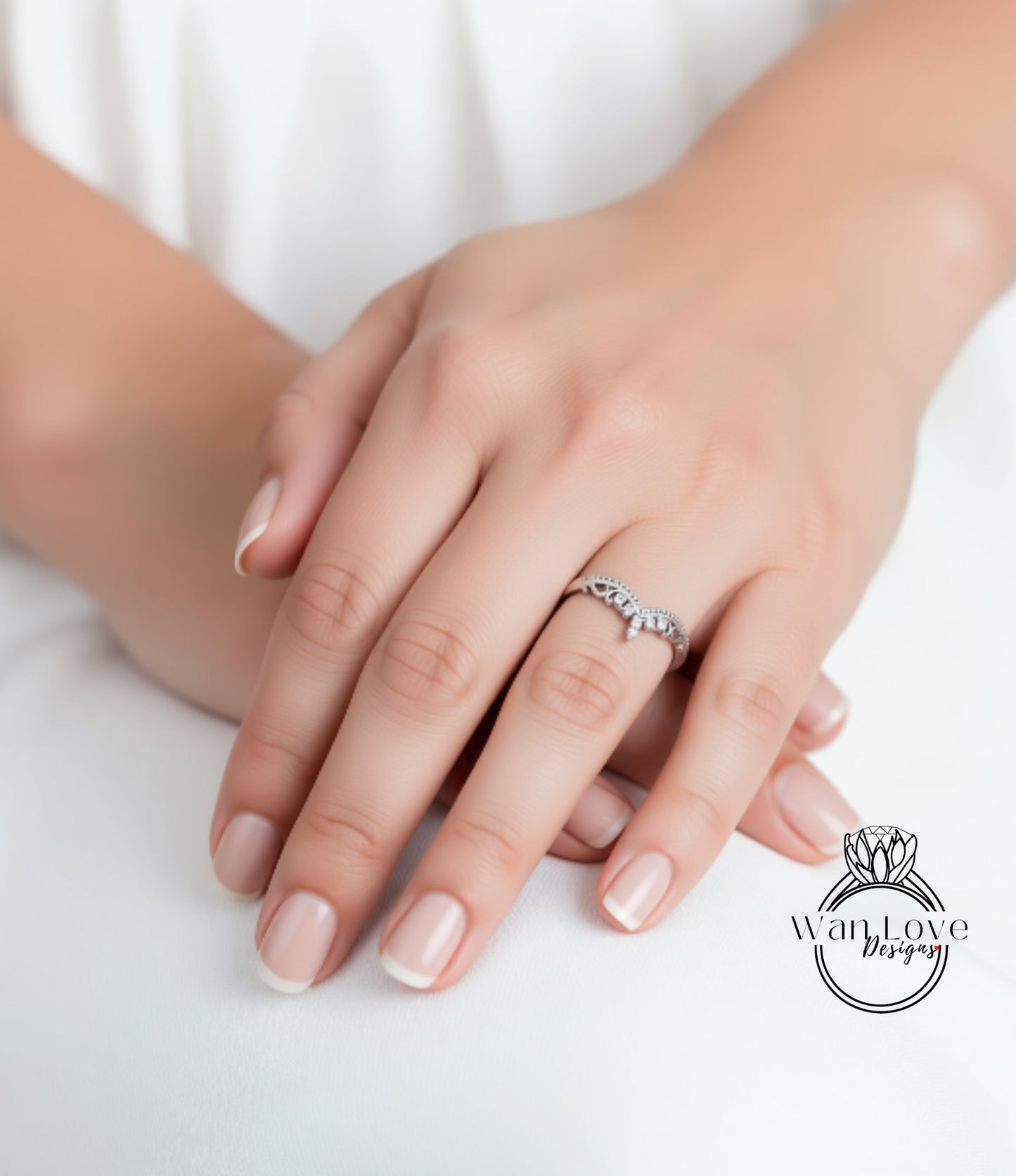 A close-up image of a person's hand wearing a ring, with the ring's design visible.