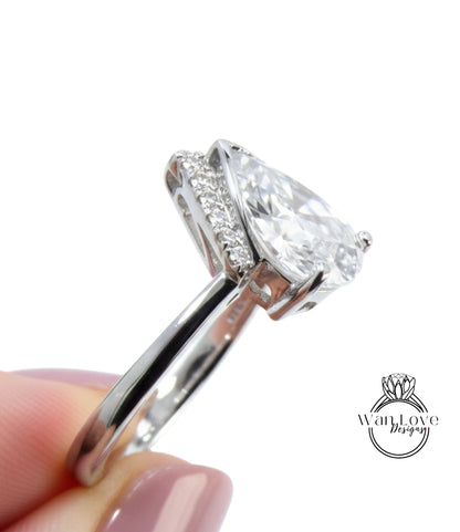 A close-up image of a person's hand holding a silver ring with a large, clear gemstone, likely a diamond.