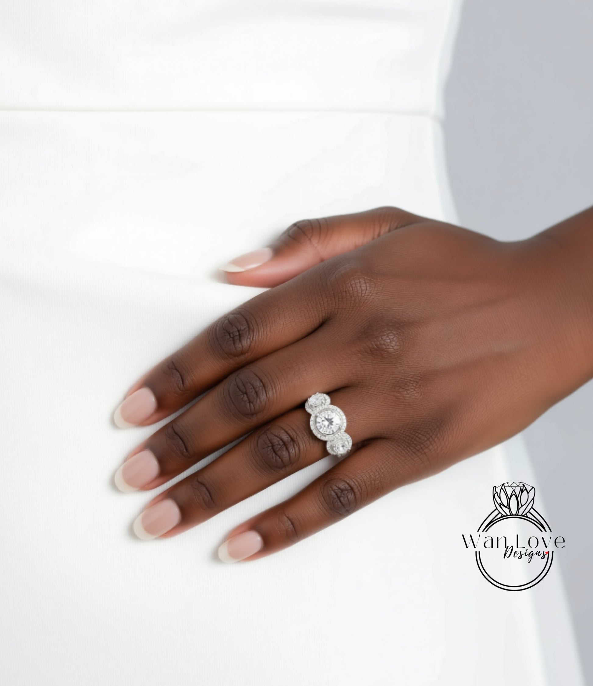 A close-up of a hand wearing a diamond ring on the ring finger.