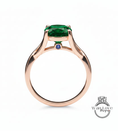 A rose gold ring with a large green gemstone, possibly a diamond, set in the center.
