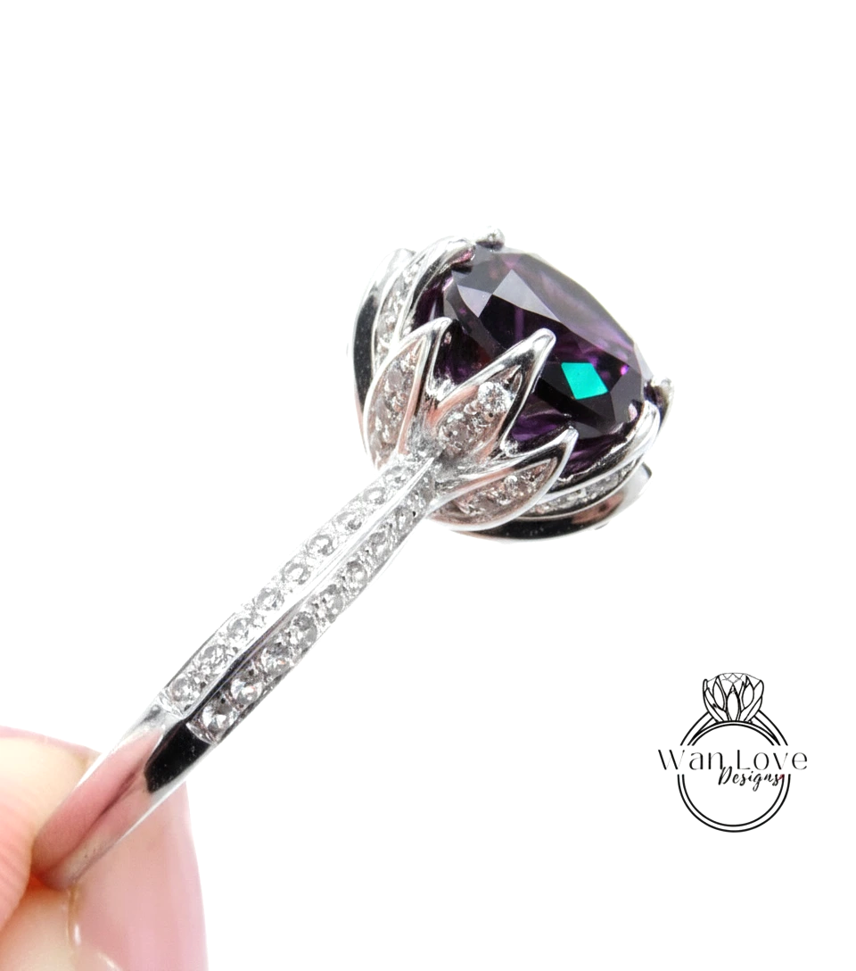 A close-up view of a silver ring with a large purple gemstone, possibly a sapphire, set in a decorative design.