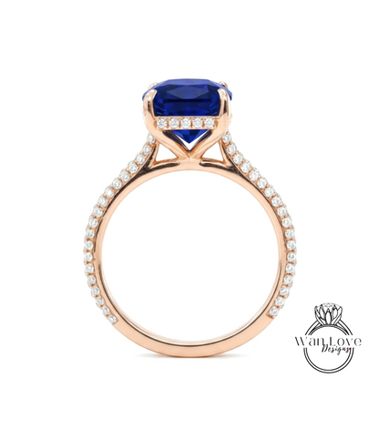A gold ring with a large blue gemstone, likely a sapphire, set in the center. The ring has a delicate band adorned with small diamonds.