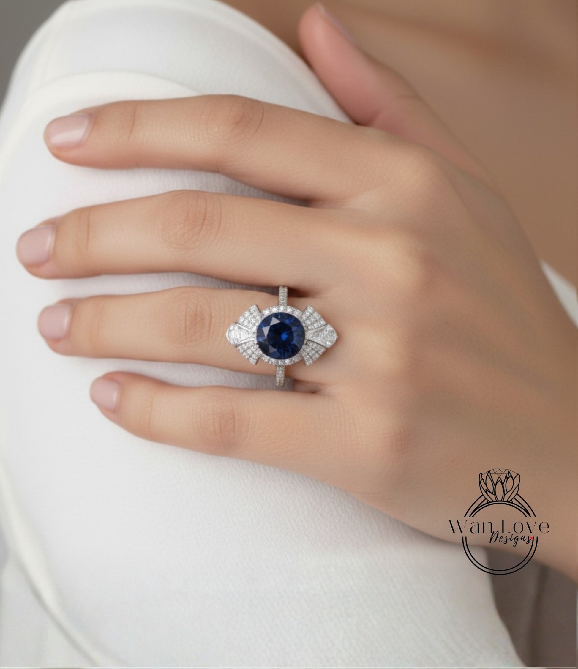 A close-up of a hand wearing a diamond ring with a large blue gemstone.