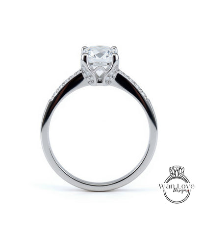 A silver engagement ring with a large central diamond and a smaller diamond accent on the band.