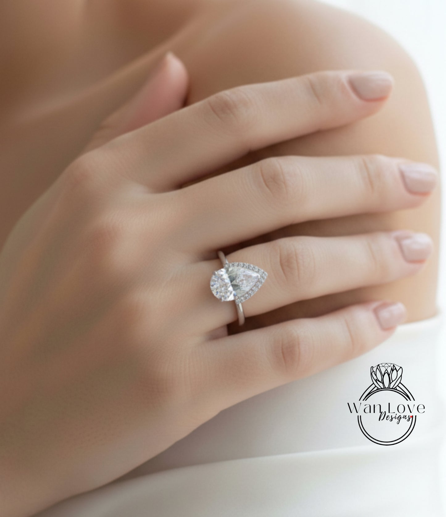 A close-up of a person's hand wearing a diamond engagement ring.