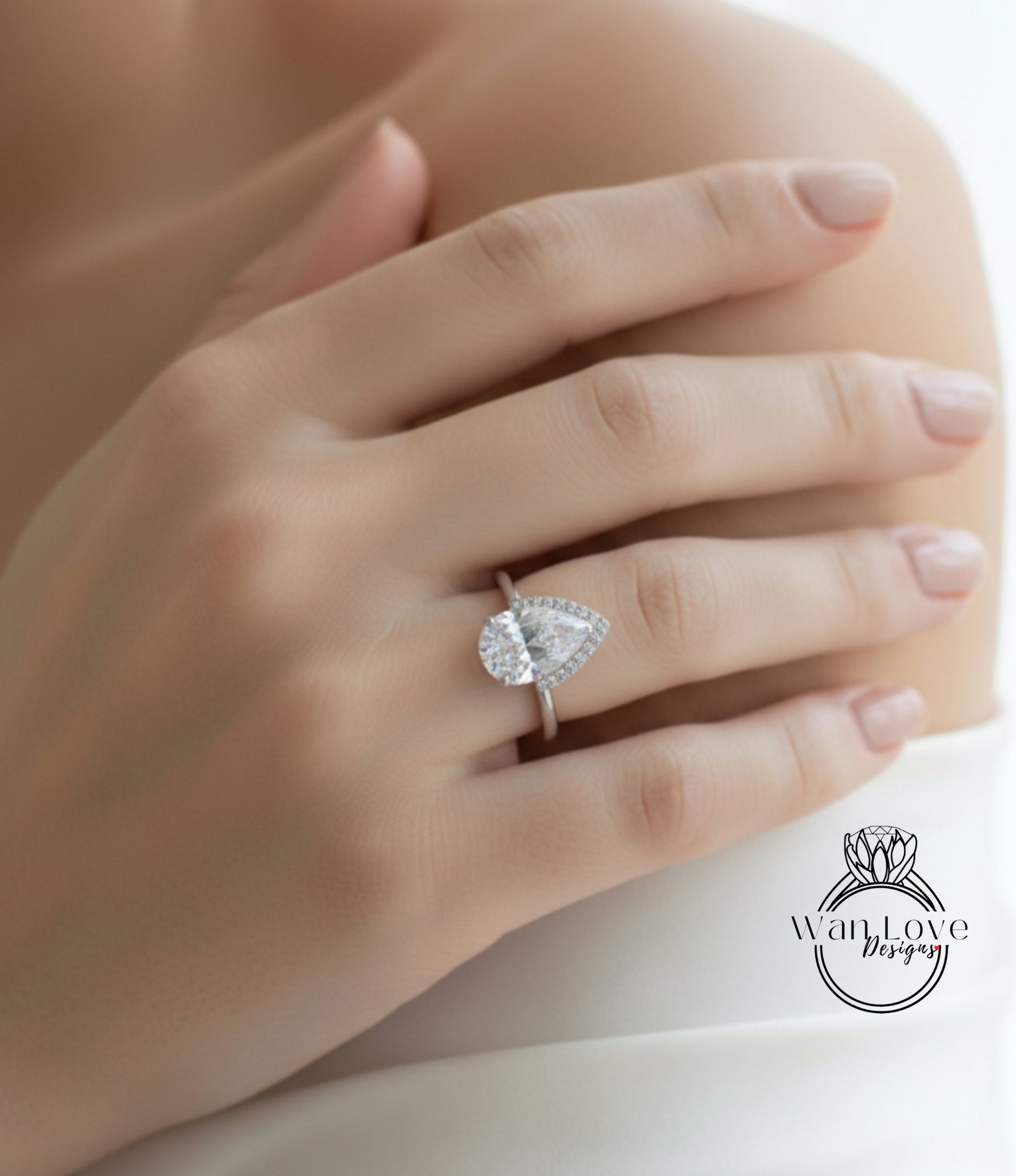 A close-up of a person's hand wearing a diamond engagement ring.
