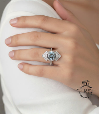 A close-up of a person's hand wearing a large, ornate ring with a blue gemstone.