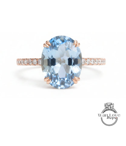 A beautiful blue gemstone ring with a rose gold band and small diamonds.