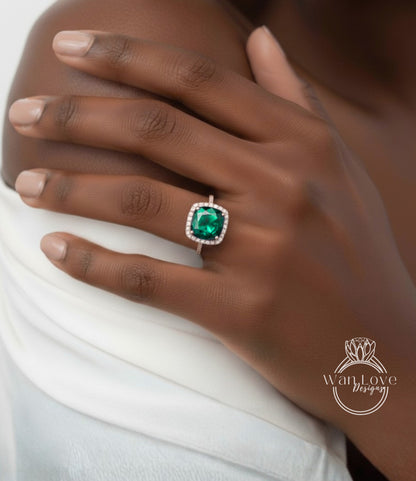 A close-up of a person's hand wearing a ring with a large, green gemstone.