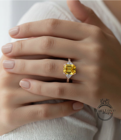 A close-up of a person's hand wearing a yellow diamond ring with a large central gemstone.