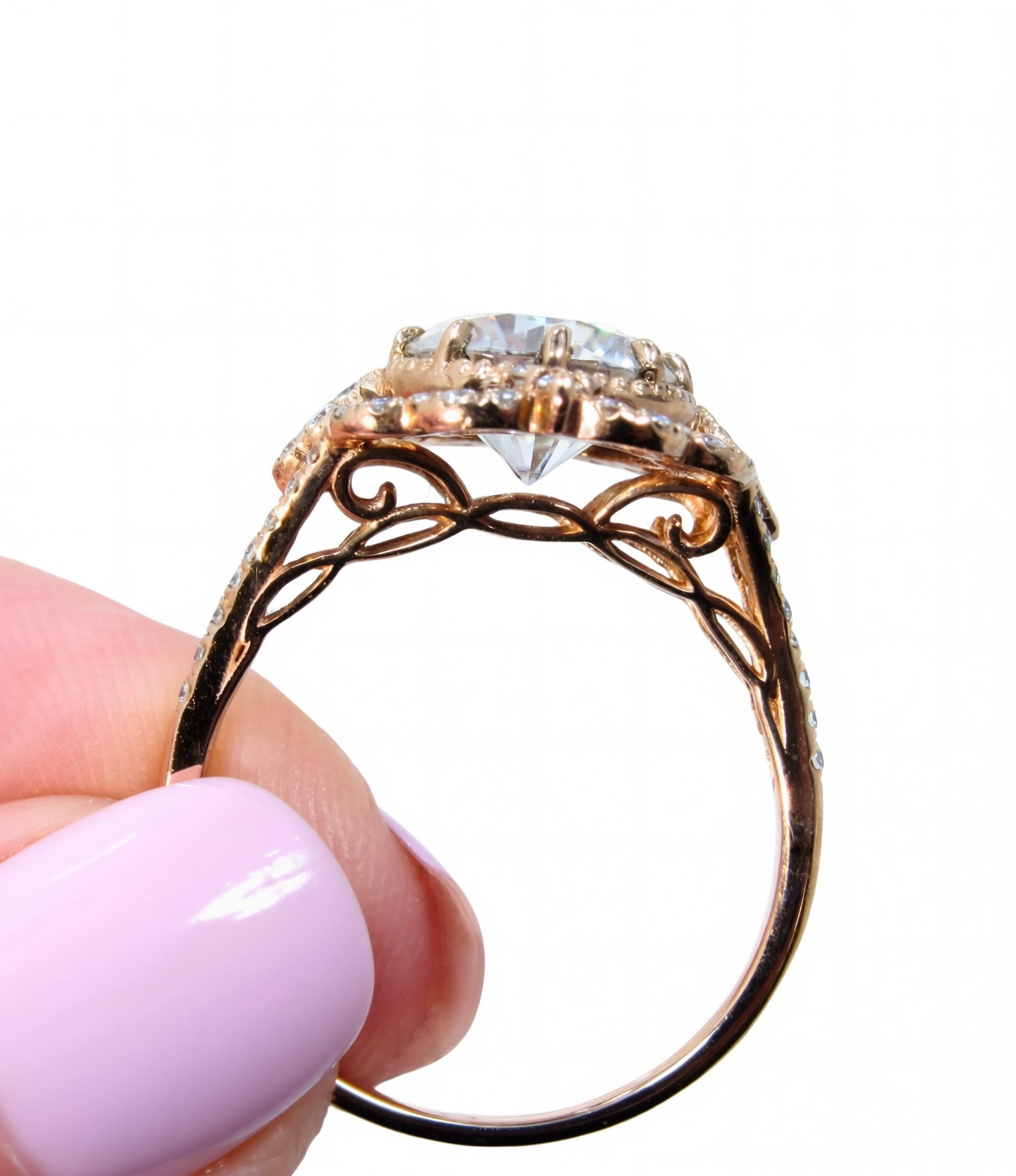 A close-up image of a hand holding a gold ring with a large diamond in the center.