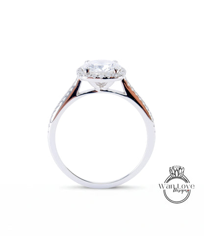 A silver engagement ring with a large central diamond and a halo of smaller diamonds around the center stone.