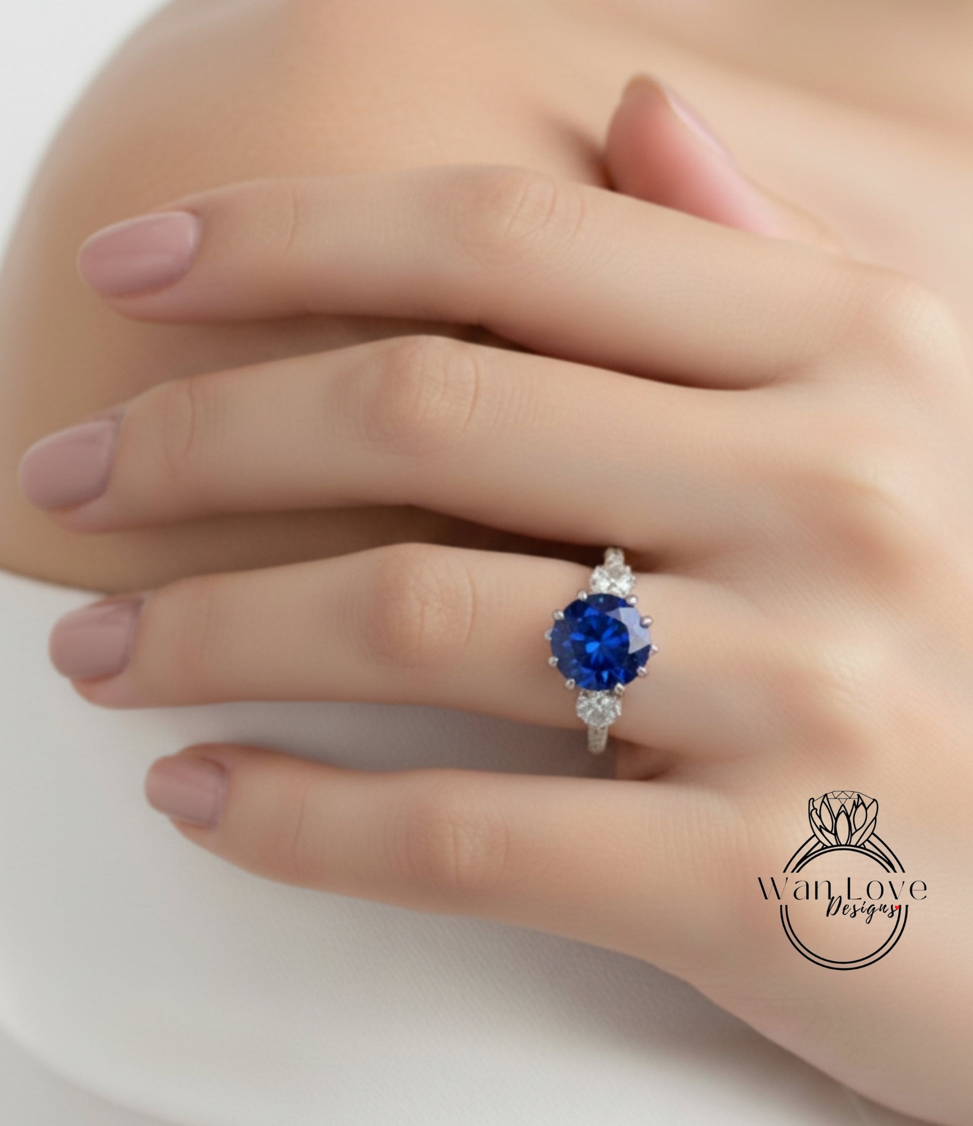 A close-up of a person's hand wearing a ring with a large blue gemstone.