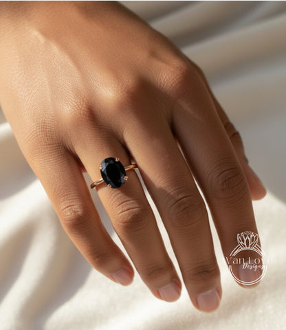 A close-up of a person's hand wearing a gold ring with a large black gemstone.
