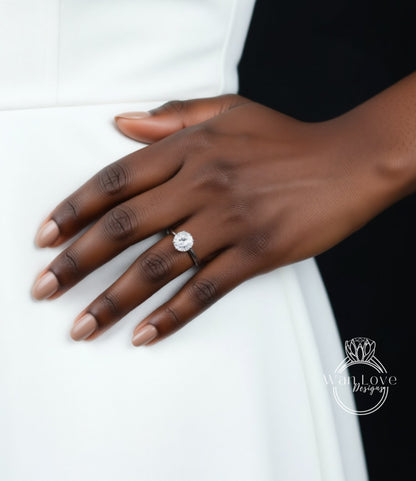 A close-up of a hand wearing a diamond engagement ring on the ring finger.