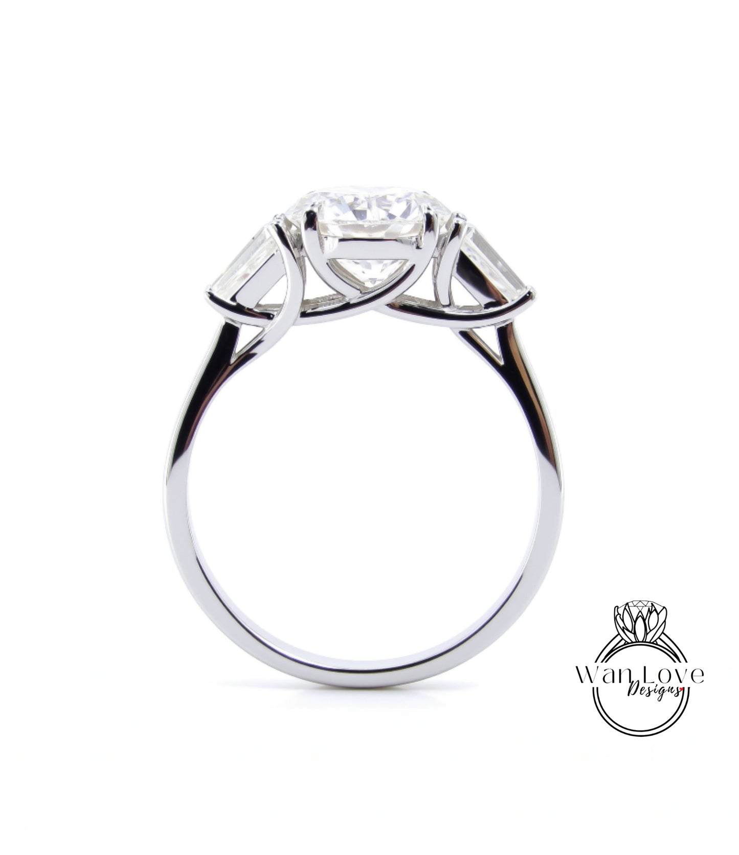 A silver engagement ring with a large central diamond surrounded by smaller diamonds on either side.