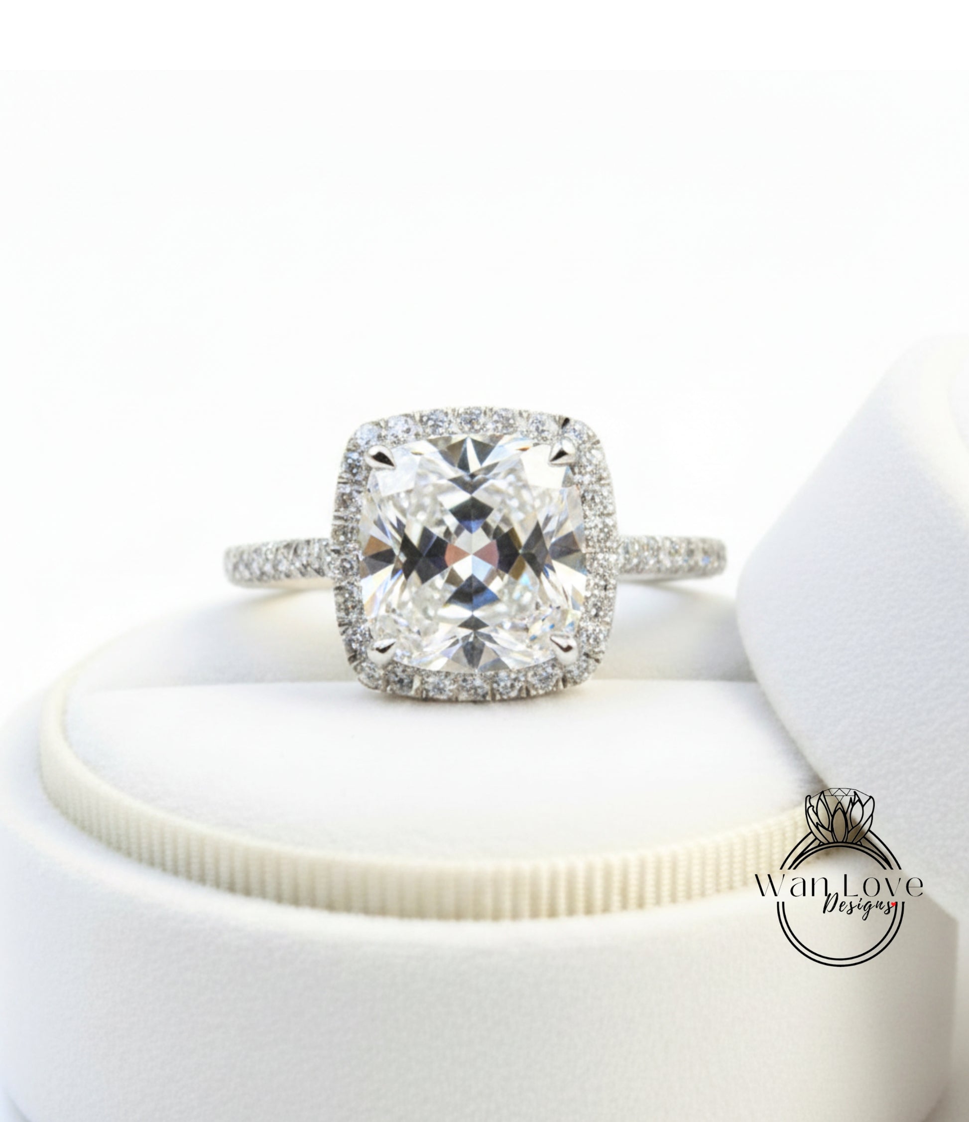 A large, clear diamond engagement ring with a halo of smaller diamonds around the center stone, displayed on a white background.
