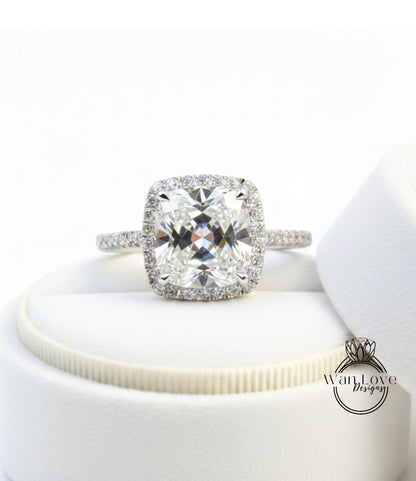 A large, clear diamond engagement ring with a halo of smaller diamonds around the center stone, displayed on a white background.