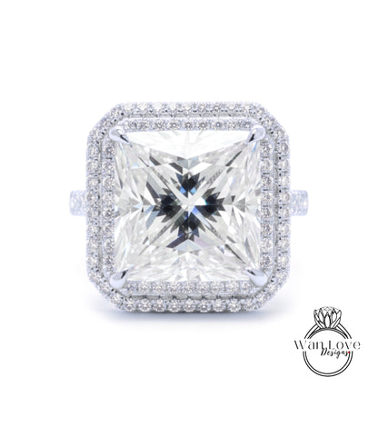 A large, square diamond ring with a halo of smaller diamonds around the edges, set in a silver band.