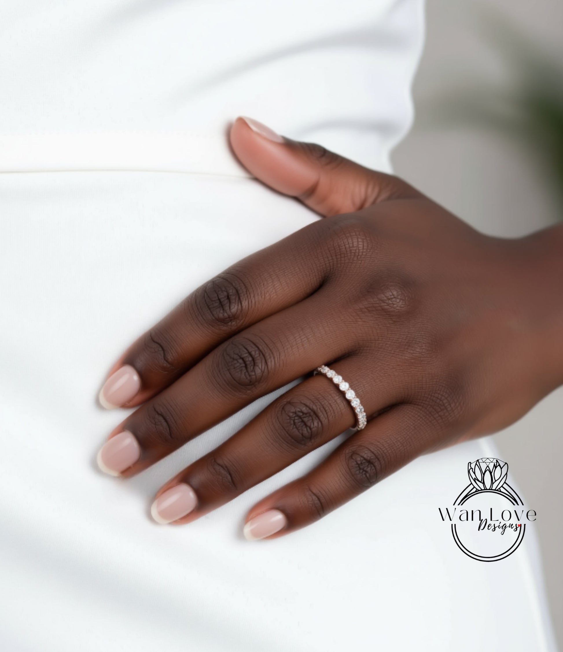 A close-up of a person's hand wearing a diamond ring on the ring finger.