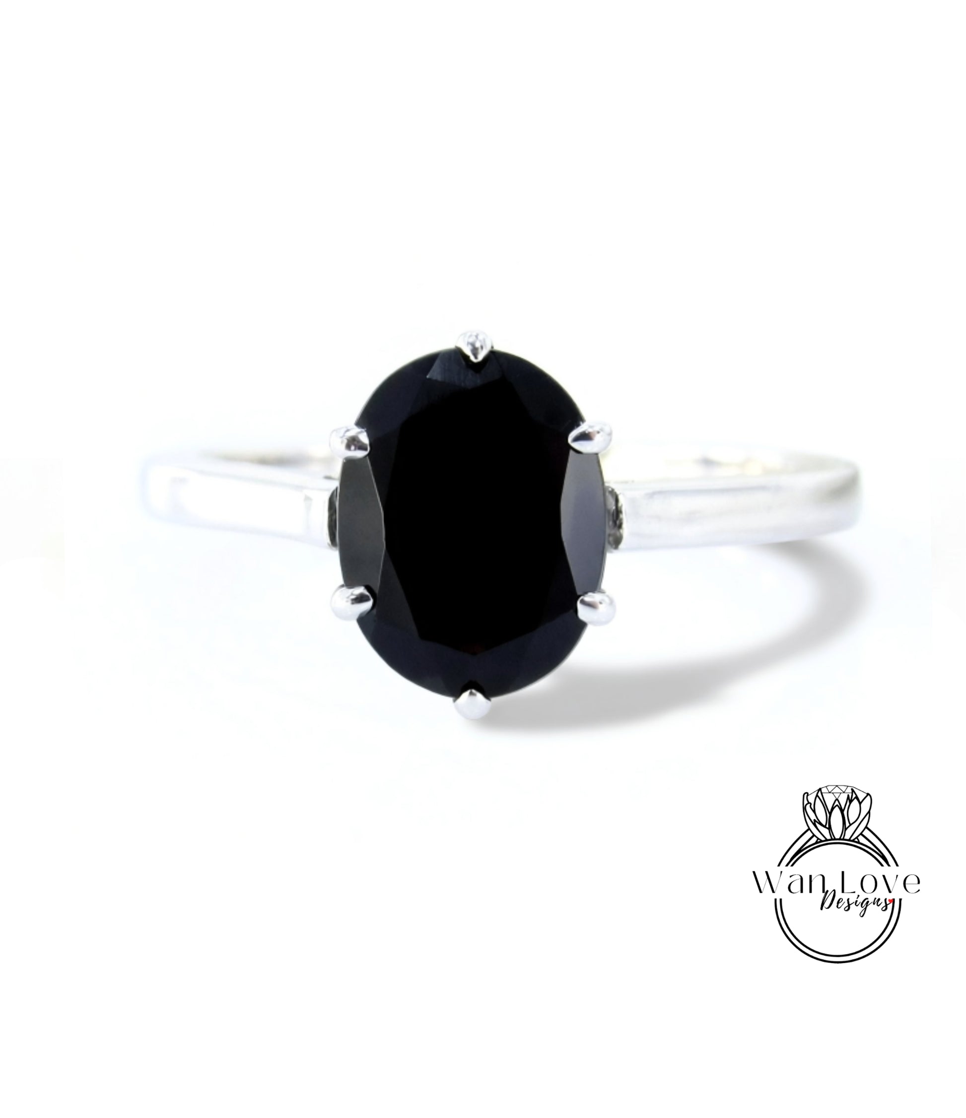 A silver ring with a large oval-shaped black gemstone, which appears to be a diamond.