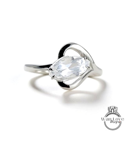 A close-up view of a silver ring with a large, clear gemstone set in the center.
