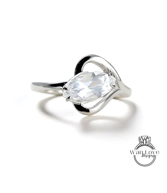 A close-up view of a silver ring with a large, clear gemstone set in the center.