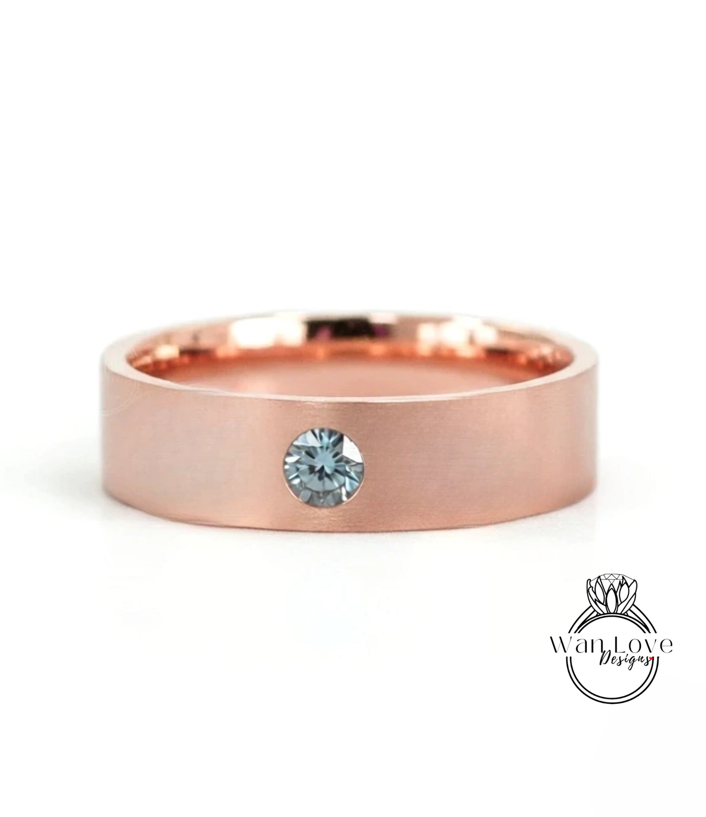 A rose gold band with a single blue gemstone set in the center.