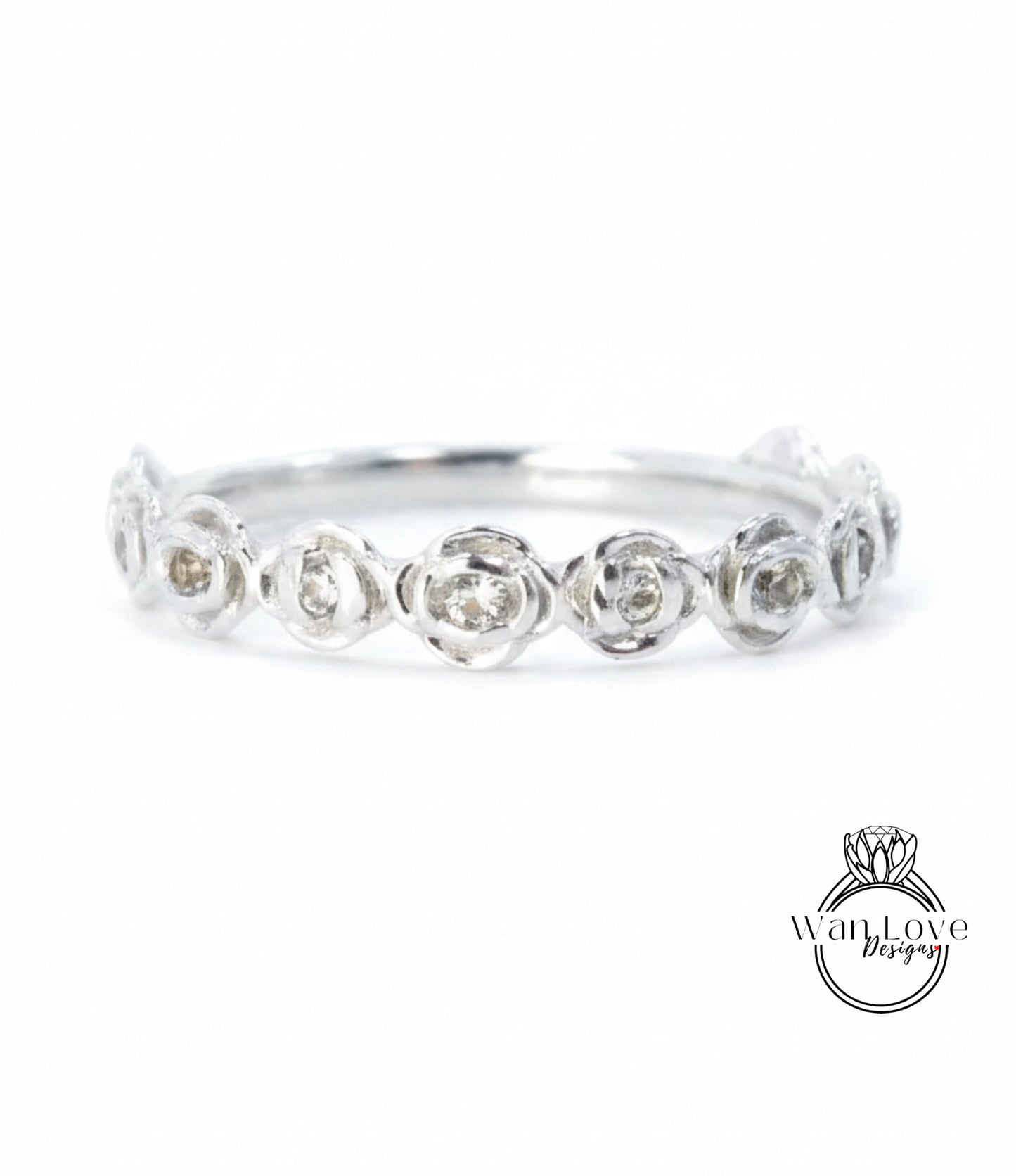 A silver ring with a row of small, round diamonds set in the center.