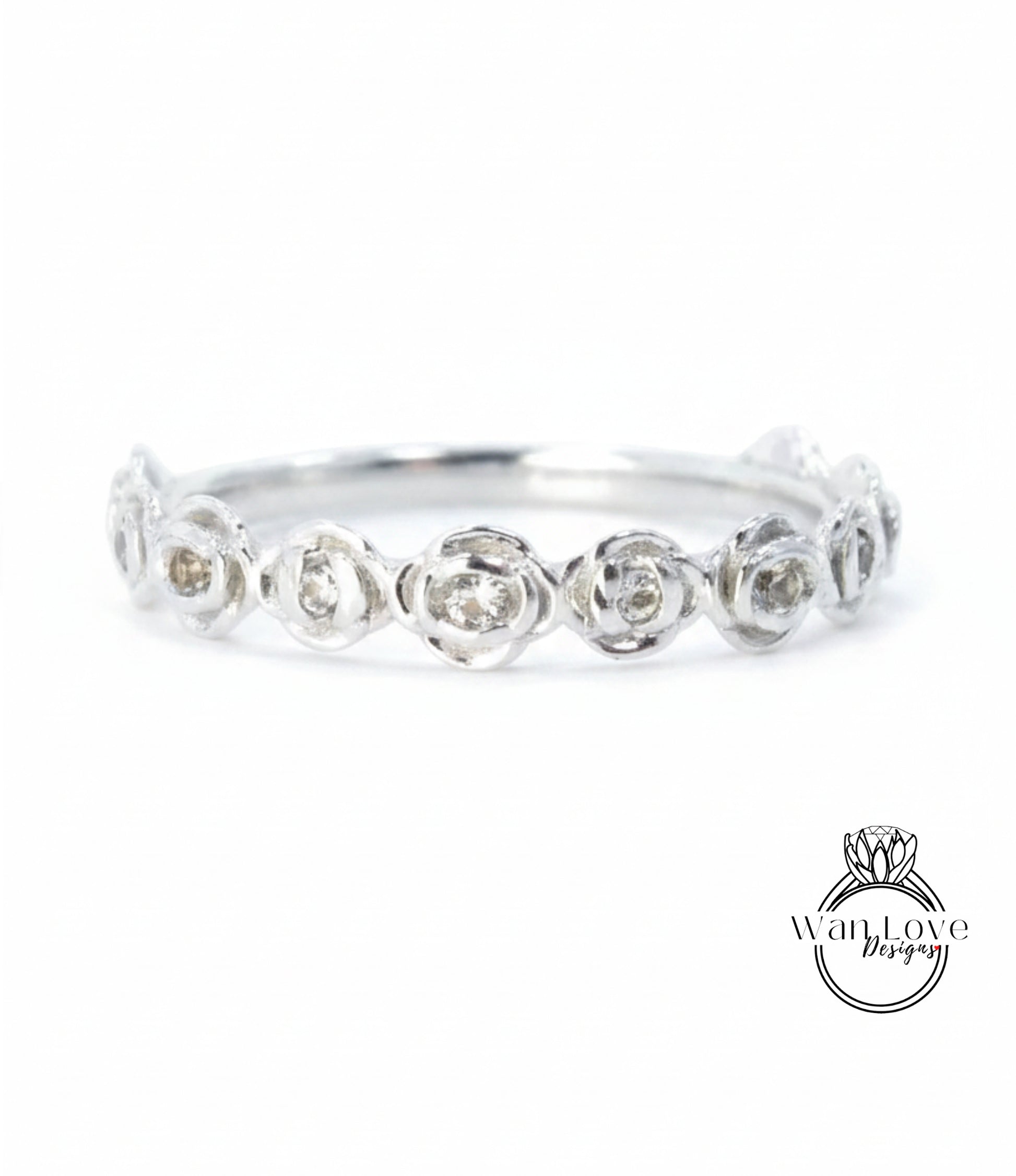 A silver ring with a row of small, round diamonds set in the center.