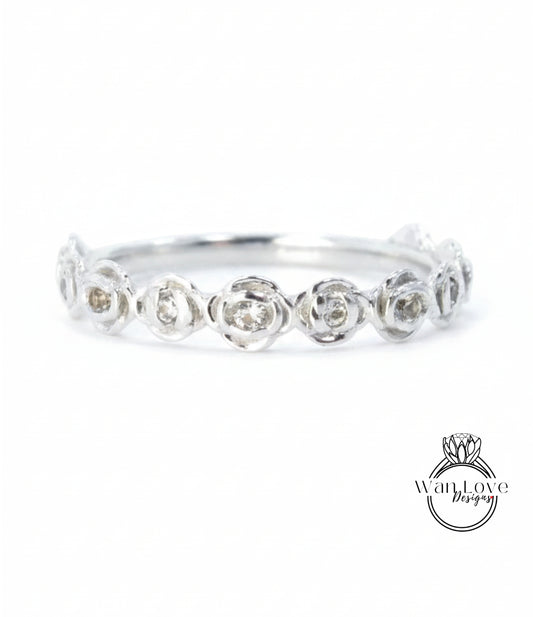 A silver ring with a row of small, round diamonds set in the center.