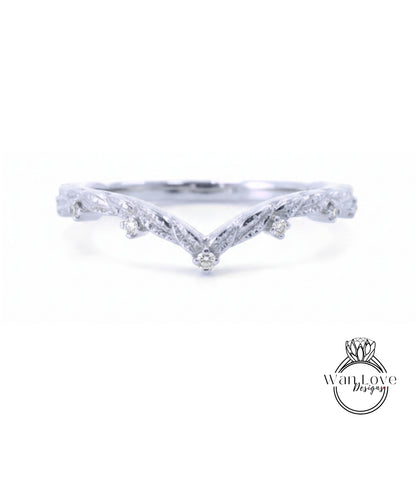 A silver ring with a v-shaped design and small diamonds set in the center.